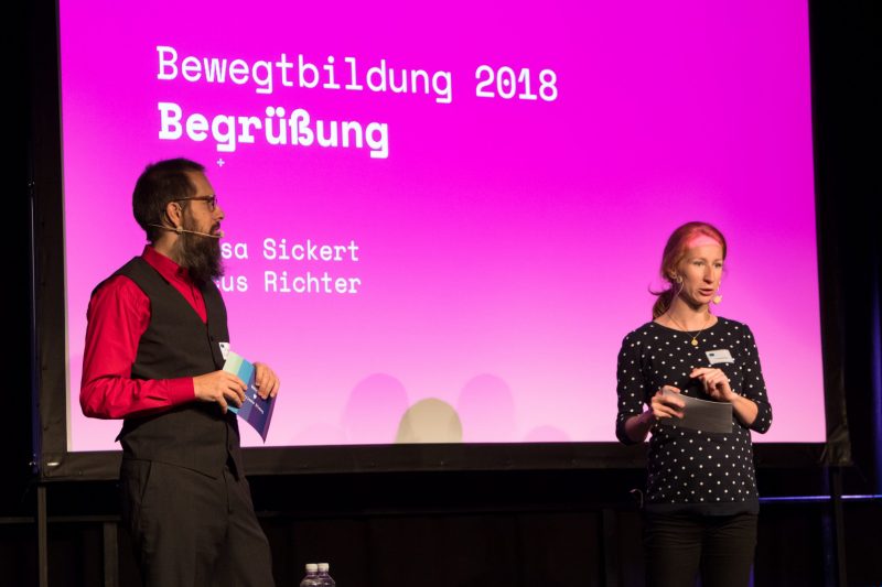 Die beiden Moderatoren Markus Richter und Theresa Sickert begrüßen die Teilnehmenden der Fachtagung Bewegtbildung 2018