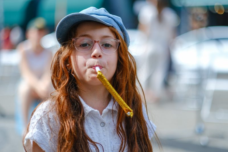 Mädchen bläst in eine Papiertröte